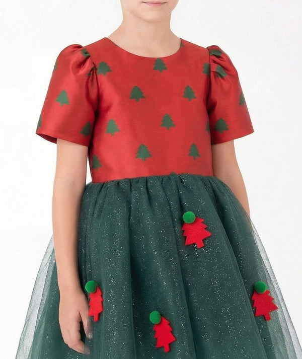 Close-up of Mama Luma's festive girls' tulle dress featuring a red Christmas tree bodice, shimmering forest-green tulle, and dimensional holiday appliqués.