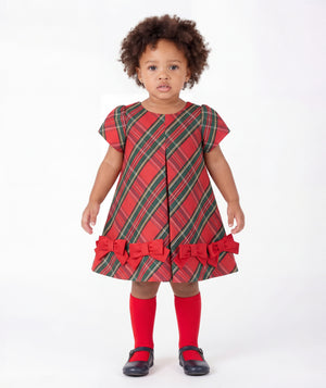Front view of Mama Luma Tartan Baby Girl Bow Dress with red and green Christmas tartan, short sleeves, and decorative scarlet bows for babies ages 12 to 36 months.