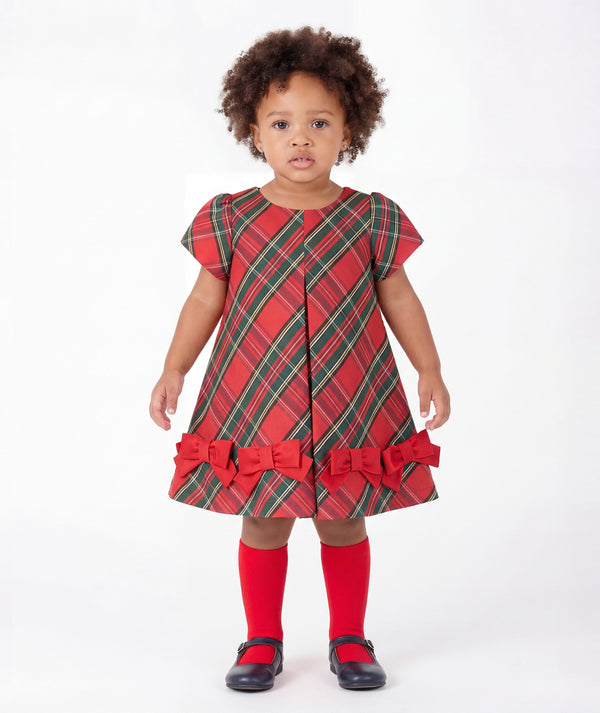Front view of Mama Luma Tartan Baby Girl Bow Dress with red and green Christmas tartan, short sleeves, and decorative scarlet bows for babies ages 12 to 36 months.