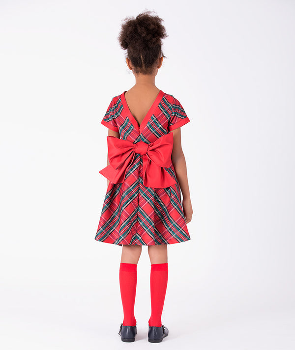 Back view of Mama Luma Zermatt Tartan Bow Girls Dress showcasing the V-shaped opening, oversized red bow, and flared plaid skirt for girls ages 3 to 12.